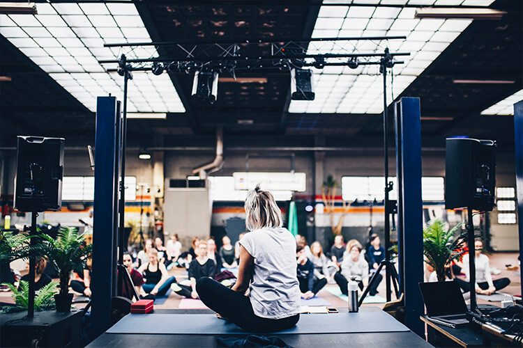 person hosting yoga event from stage